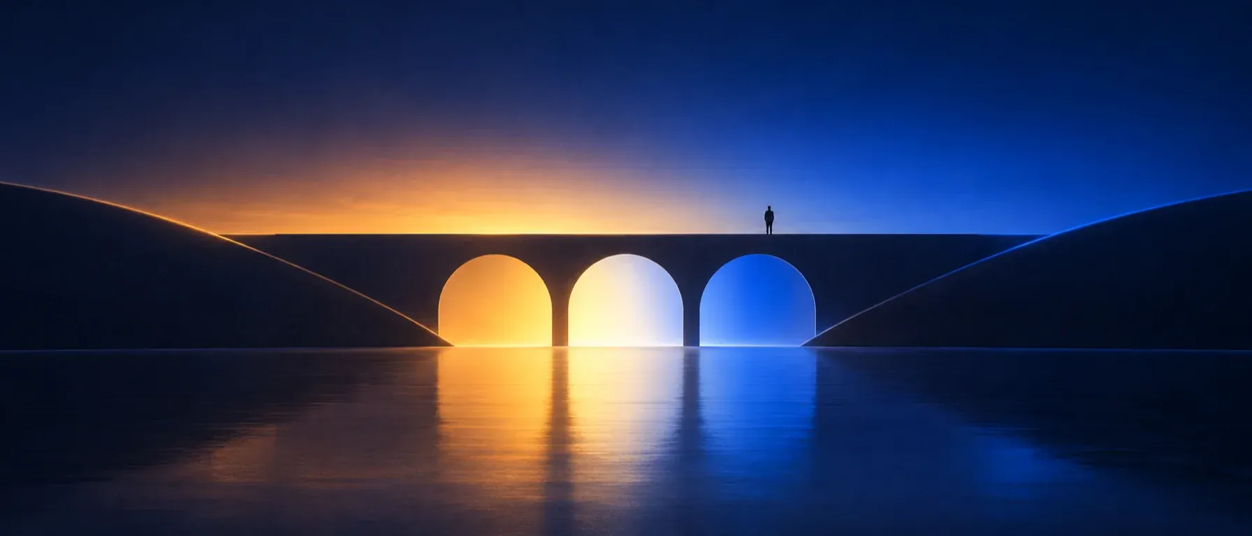 A bridge of three arches over still water, lit amber, white and blue, with a lone figure standing on top.